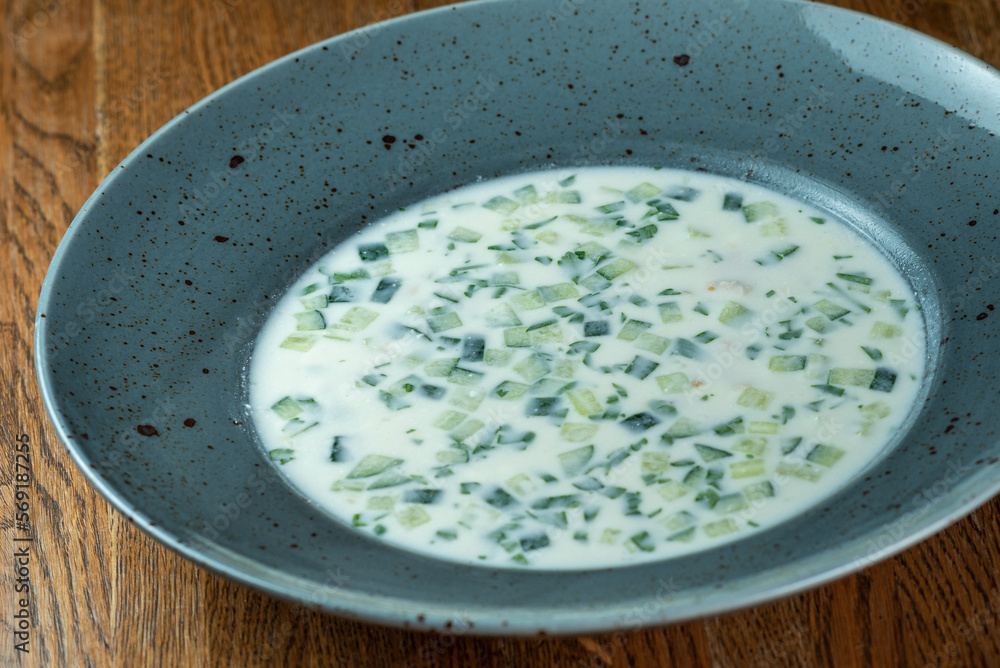 Okroshka with kefir, herbs and cucumbers in a blue plate Okroshka with kefir, herbs and cucumbers in a blue plate