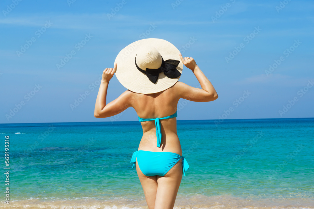 A beautiful woman in a swimsuit posing on a Thai beach at summer. Concept of holiday, vacation, traveling and resort.