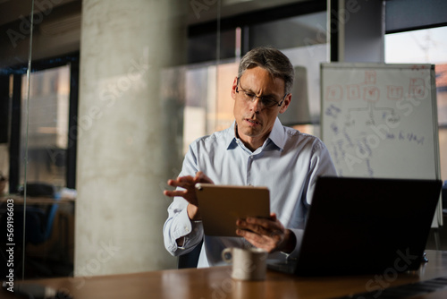 Wallpaper Mural Portrait of businessman in office. Man using digital tablet. Businessman having video call Torontodigital.ca