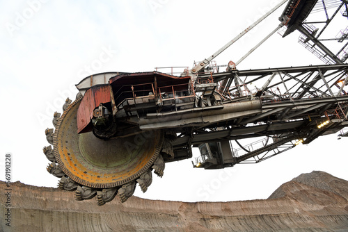 Bucket-wheel excavator during excavation at the surface mine. Huge excavator on open pit mine.