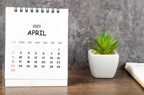 The April 2023 Monthly desk calendar for 2023 with diary on wooden table.