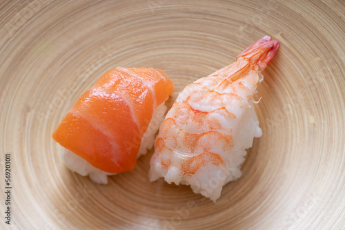 Nigiri sushi with shrimp and salmon on a bamboo dish