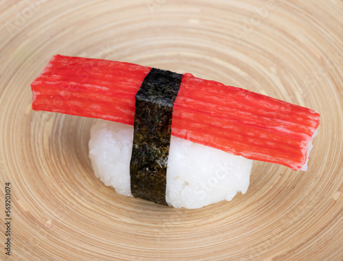 Nigiri sushi with surimi, rice and nori on a bamboo dish