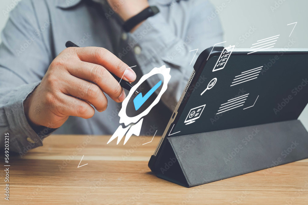Fototapeta premium Businessman show icon of top service Quality assurance, Customer rating to service experience and Warranty online application concept, Guarantee, Standards, ISO certification and use laptop on table.