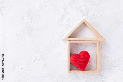 Wooden small house with red heart for happy family. Real estate, sweet home, investment, mortgage and buy new property concept.