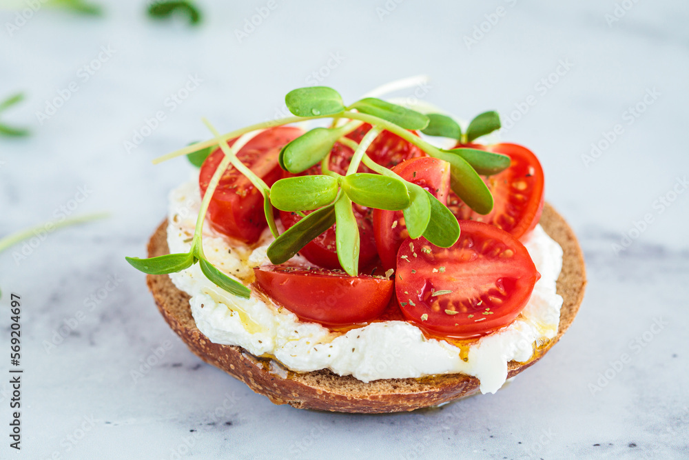 Toast with cream cheese, cherry tomatoes and micro greens. Healthy breakfast concept. Toast with cream cheese, cherry tomatoes and micro greens. Healthy breakfast concept.