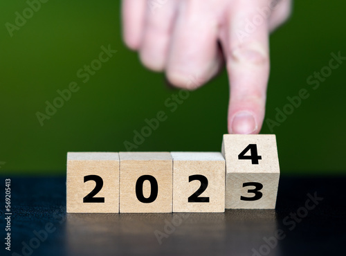 Hand turns cube and changes the year 2023 to year 2024.