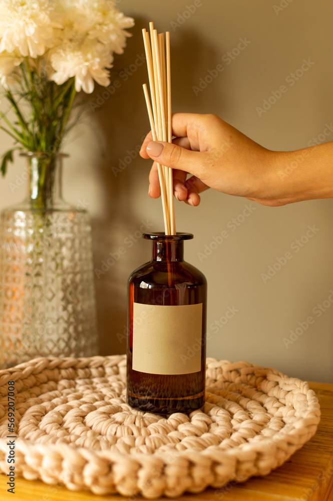 Naklejka premium Hand placing toothpick into aroma diffuser