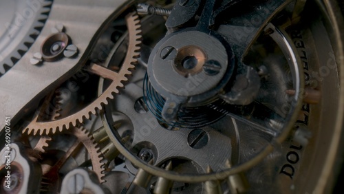 Antique pocket watch internal mechanism. Macro shot of clockwork of stopped clock with spring, gears, cogwheel and wheels with tootheds. Disassembled silver retro pocket watch inside. Clock workshop.