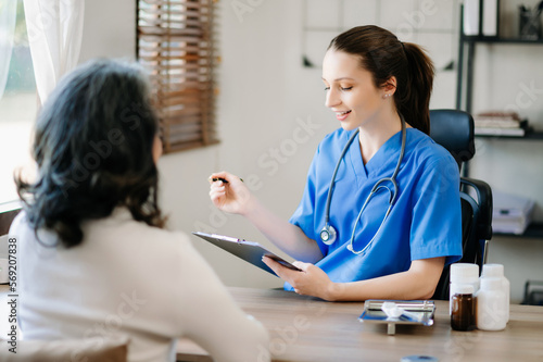 Asian Doctor and patient discussing something while sitting at the table . Medicine and health care concept. .