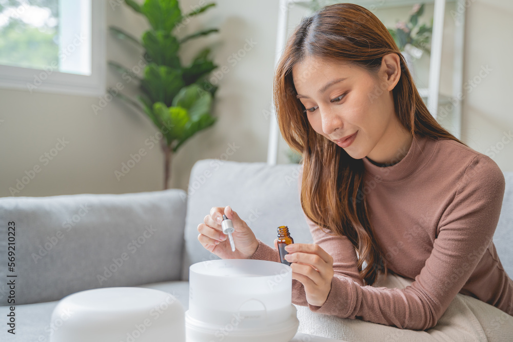 Women drop essential oil into the humidifier to make aromatherapy refreshments atmosphere house for relaxation. Women drop essential oil into the humidifier to make aromatherapy refreshments atmosphere house for relaxation.