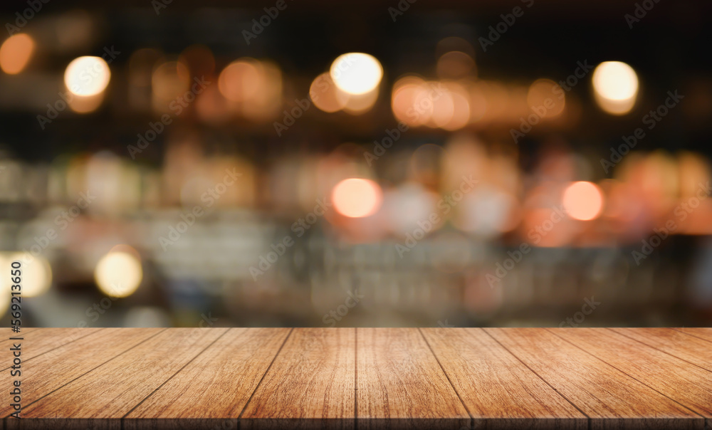 Empty wooden table top with lights bokeh on blur restaurant background.	