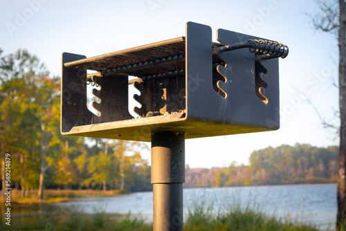 Charcoal grill at a park by a lake.