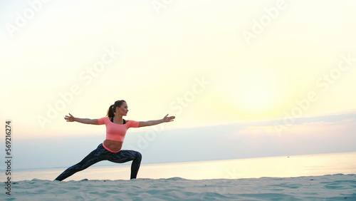 Healthy, young beautiful woman meditating, practicing yoga on the sea beach, at sunrise, Makes exercises for balance and coordination, deep muscle tone. close up