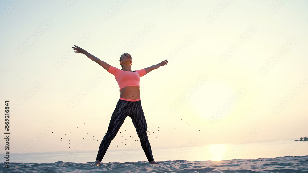 Healthy, young beautiful woman meditating, stretching, practicing yoga on the sea beach, at sunrise, Makes exercises for balance and coordination, deep muscle tone. Healthy, young beautiful woman meditating, stretching, practicing yoga on the sea beach, at sunrise, Makes exercises for balance and coordination, deep muscle tone.