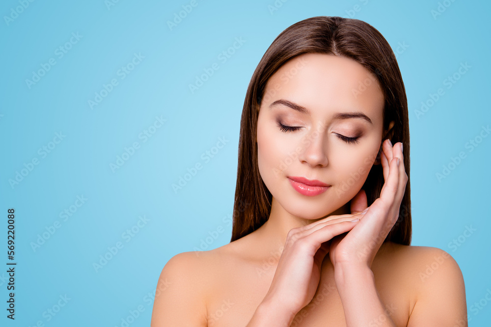 Close up photo of happy smiling beautiful girl with closed eyes touching her smooth skin after applying moisturizing lotion, isolated on grey background, copyspace Close up photo of happy smiling beautiful girl with closed eyes touching her smooth skin after applying moisturizing lotion, isolated on grey background, copyspace