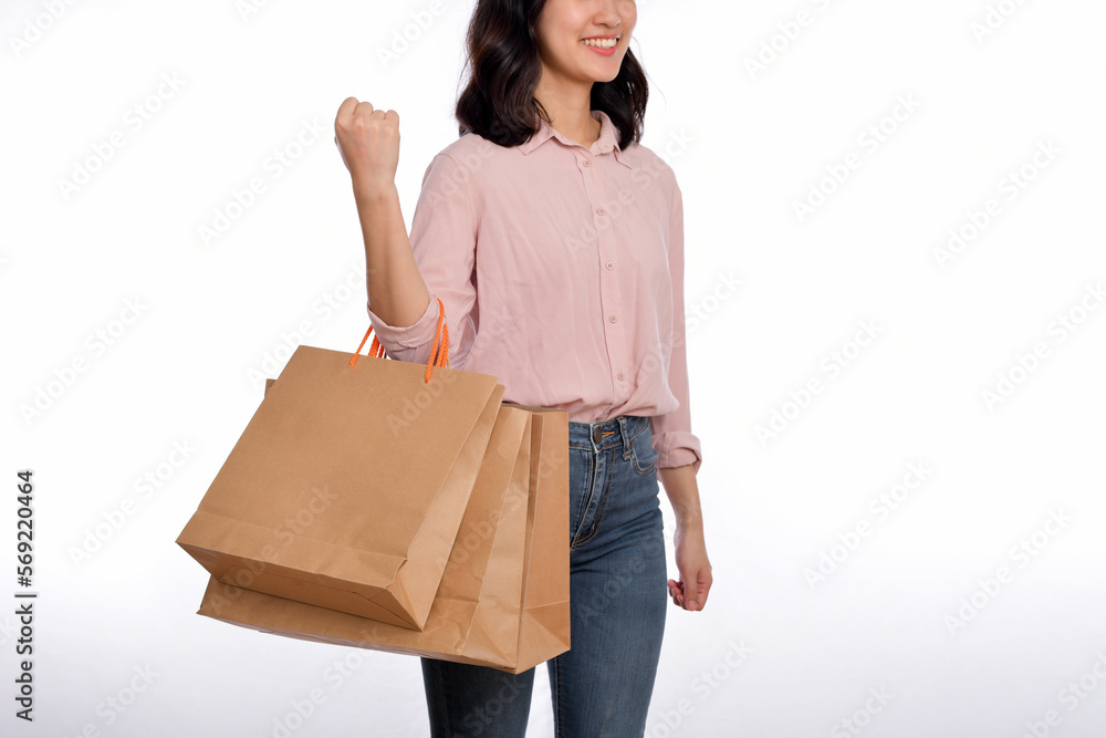 Young happy asian woman with casual shirt and denim jeans holding shopping paper bag isolated on white background