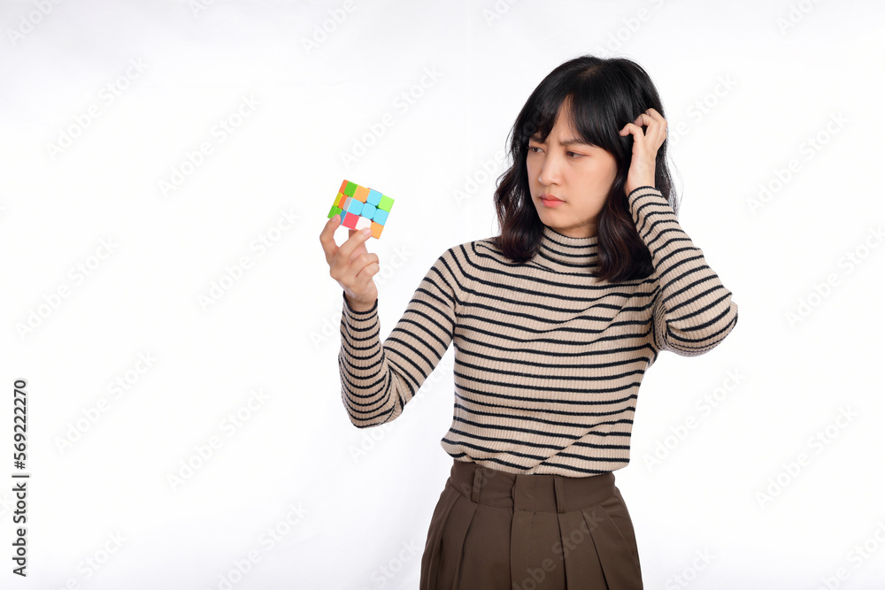 Obraz na plátně Asian woman holding a puzzle cube standing on white background