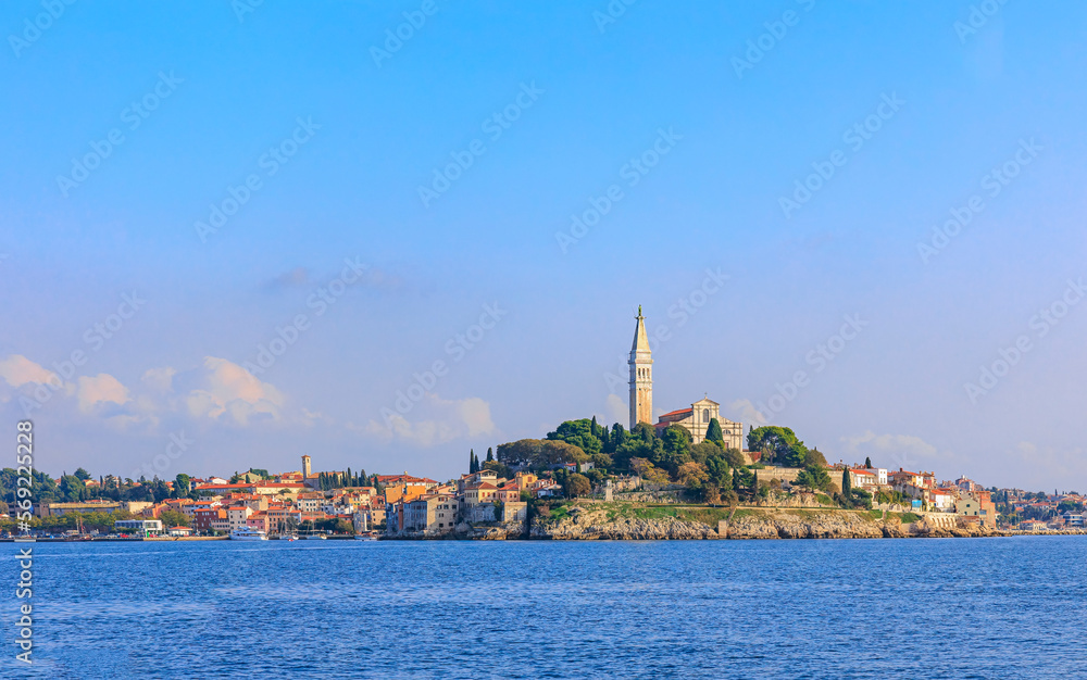 Fototapeta premium The old town of Rovinj with the church of St. Euphemia seen from the sea on a sunny day with blue sky