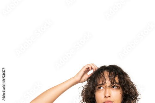 closeup portrait headshot cropped face above lips of cute puzzled woman looking up isolated on white studio wall background with copy space above head. Human face expressions