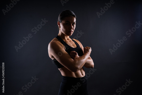 Strong sportswoman in boxing gloves prepared high kick. Isolated on white, red, yellow background
