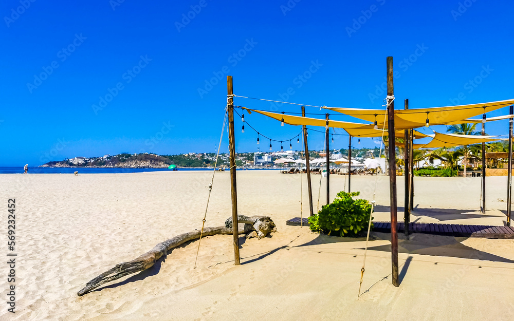 Palms parasols sun loungers beach waves Puerto Escondido Mexico. Palms parasols sun loungers beach waves Puerto Escondido Mexico.