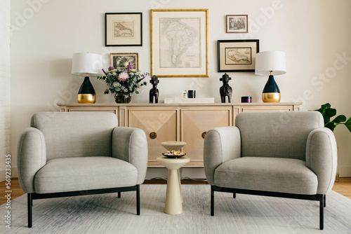 two large armchairs with small table in between them in front of console table wit gallery wall above 