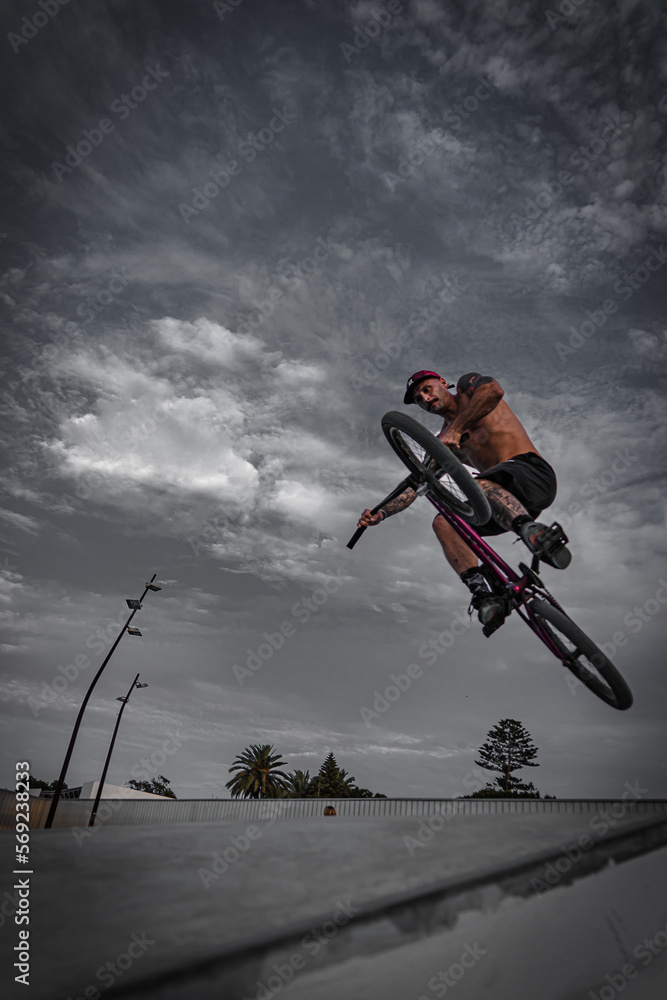 Bmx rider in the skatepark jumping with the bike. Boy with tattoos. Urban photography Bmx rider in the skatepark jumping with the bike. Boy with tattoos. Urban photography