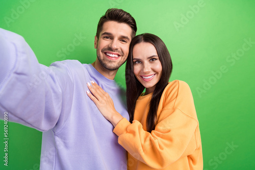 Portrait of positive guy nice lady embrace take selfie toothy smile isolated on green color background