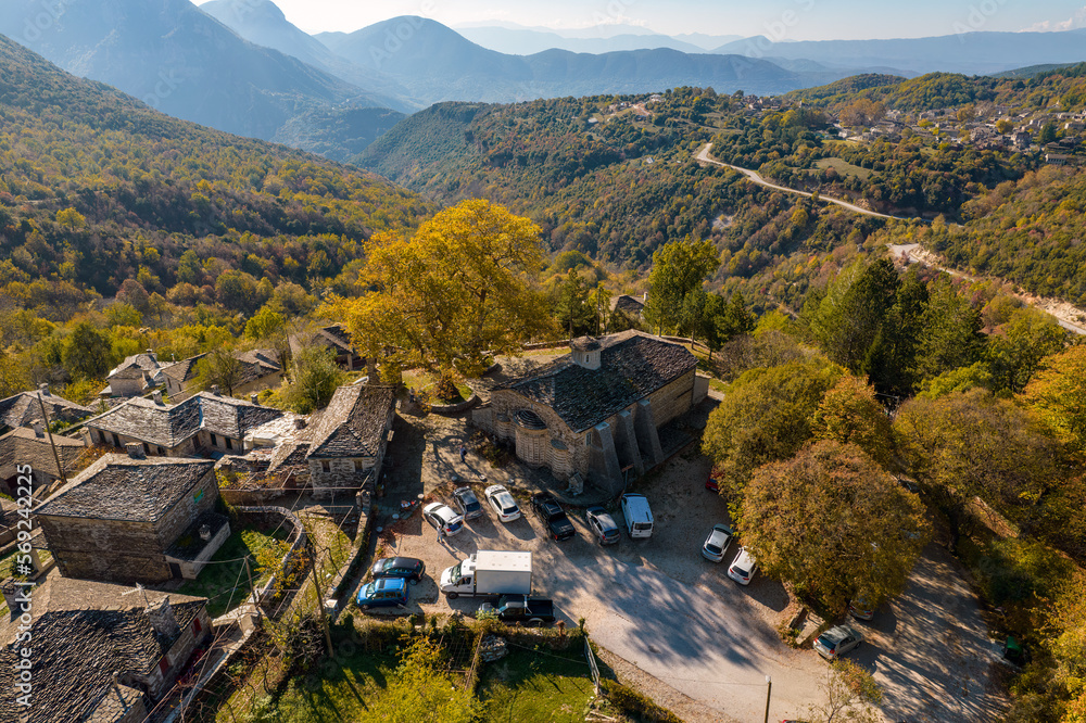 aerial view of the traditional village Mikro Papigo with with stone buildings and  astraka mountain as background during  fall season in  zagori Greece
