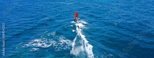 Aerial drone ultra wide photo with copy space of wind athlete surfer competing among others in deep blue open ocean sea