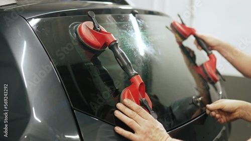 Workers replacing the windscreen of a car in a service station windshield replacement. High-quality 4k footage