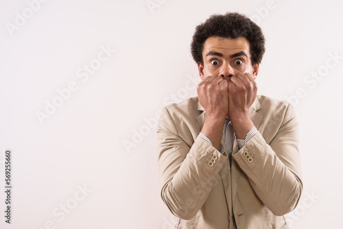 Portrait of a shocked  businessman  covering his mouth.