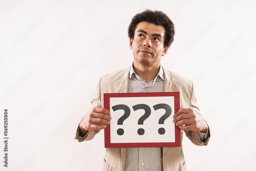 Image of confused businessman showing paper with question marks. Image of confused businessman showing paper with question marks.