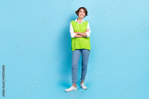 Full body portrait of positive minded creative lady folded hands look empty space isolated on blue color background