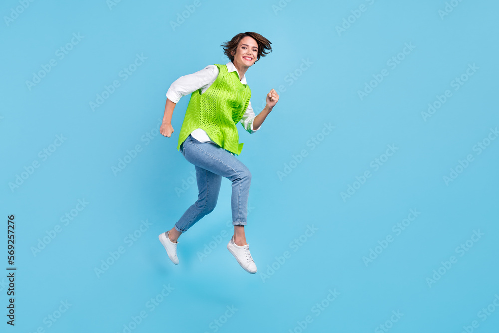 Full size photo of pleasant gorgeous girl brown hairdo wear green vest jeans running at sale shopping isolated on blue color background