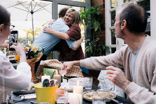 Happy parent embracing son during party at restaurant photo