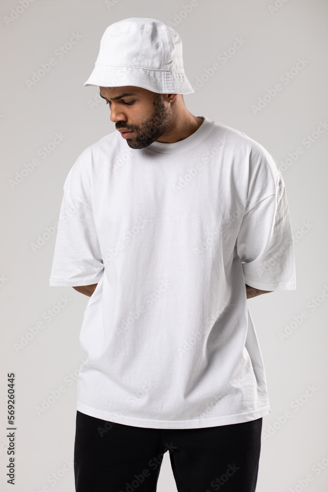 Attractive african american man with a beard dressed in a white t-shirt and panama.