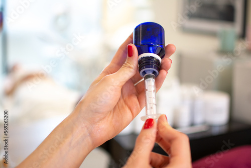 Close up of woman s hands making face injection for cosmetology procedure at beauty salon.