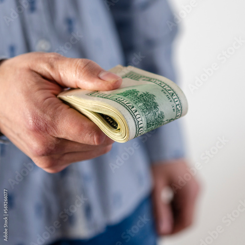 A man hands over a thick wad of dollars