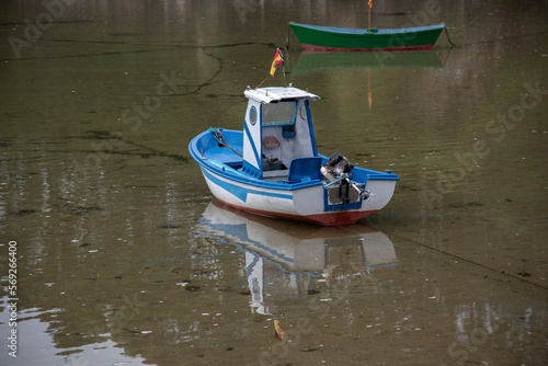 small boat anchored on the beach of O Barqueiro photo