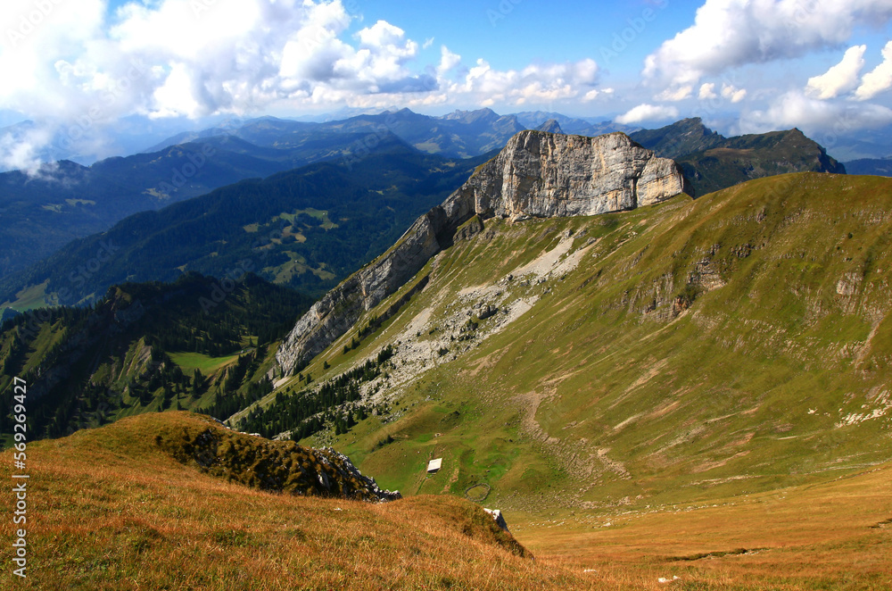 Landscape with a mountain in the foreground and long mountain ranges in the background against a blue sky with clouds on Mount Pilatus, near Lucerne, Switzerland Landscape with a mountain in the foreground and long mountain ranges in the background against a blue sky with clouds on Mount Pilatus, near Lucerne, Switzerland