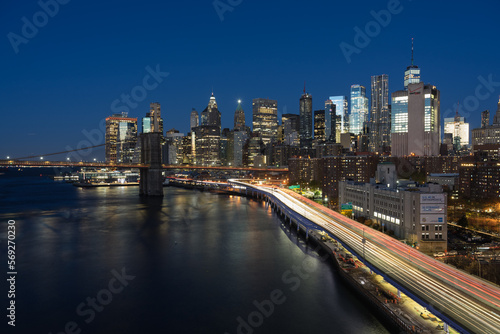 Verkehr an Fluss mit Lichtern und Brücke und Skyline in der Nacht. © hannesheigl