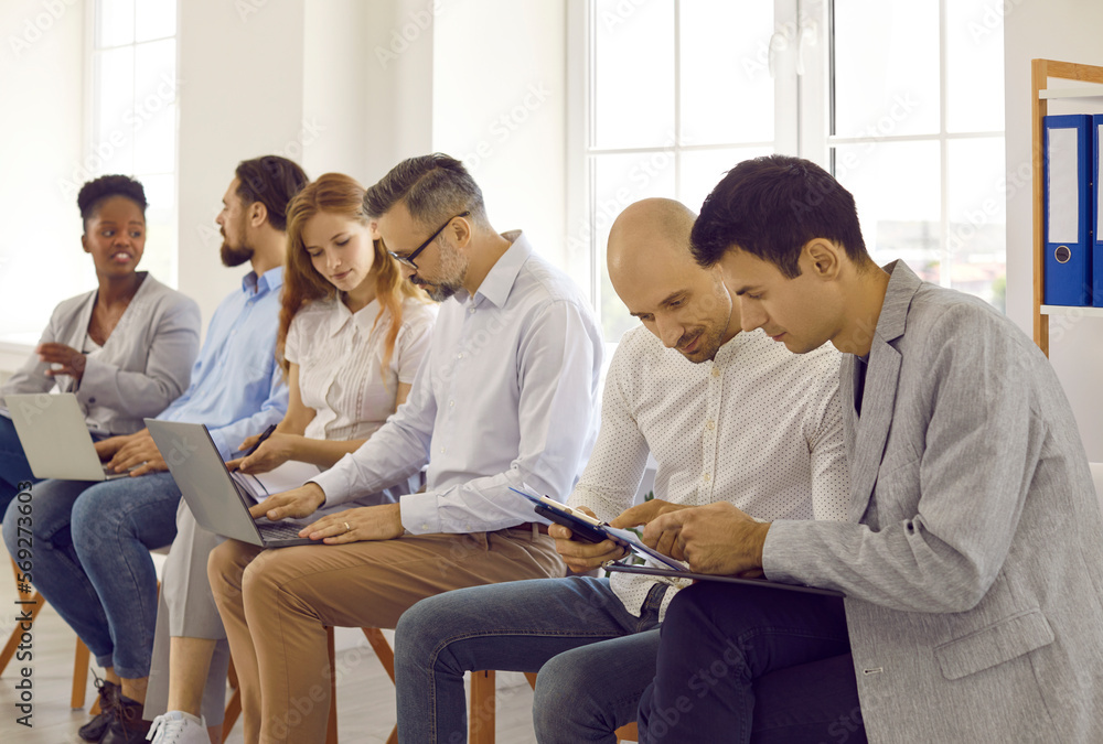 Fototapeta premium Business people on seminar training discussing in pairs making tasks together using laptops. Working and educational brainstorming process in international company. Adult education concept.