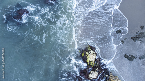 vista aerea de un mar enfurecido con grandes olas rompiendo en las rocas de un acantilado photo