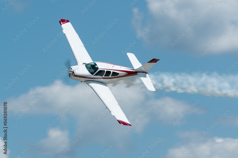 Small propeller plane flying with smoke at an airshow in the USA.  - obrazy, fototapety, plakaty 