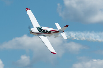 Acrylglasbilder Alte Flugzeuge Propellerflugzeug mit Rauch bei Flugshow  © Thierry