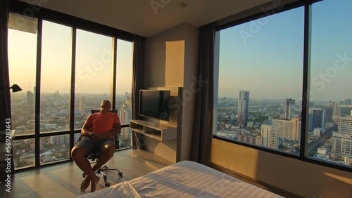 Photography Handsome man in his room in luxury hotel is looking beautiful sunrise