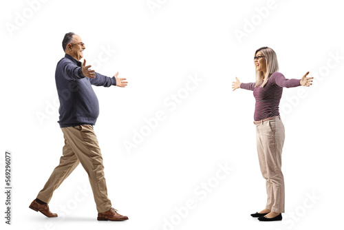 Full length profile shot of a happy mature man meeting a young woman with arms wide open