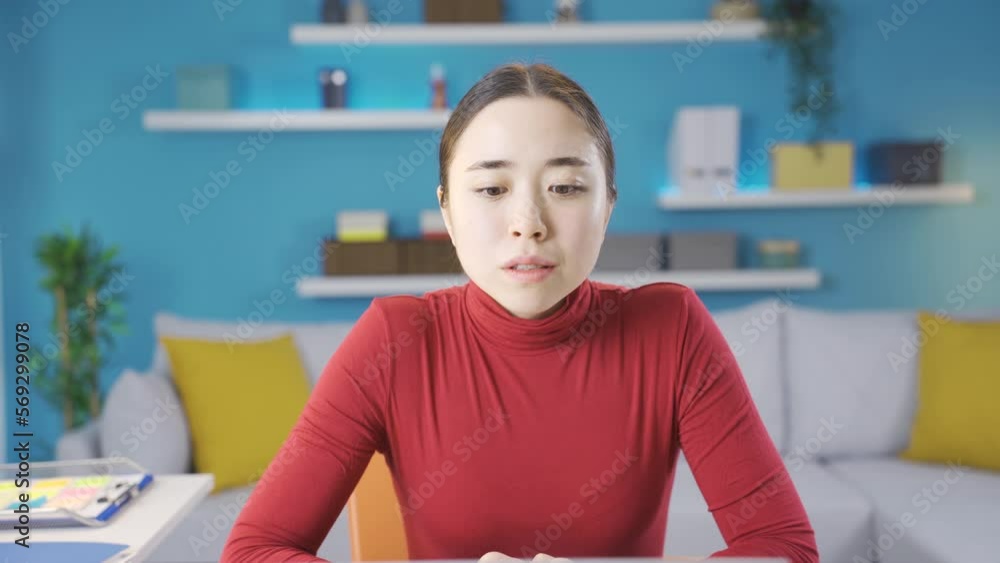 Asian woman looking at the camera with sad eyes in response to the news she saw on the laptop screen. Asian woman looking at the camera with sad eyes in response to the news she saw on the laptop screen.